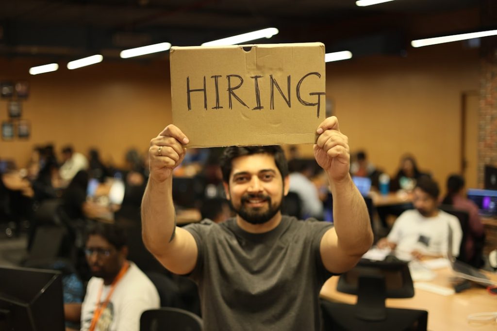 Man holding a hiring sign