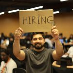 IT Staff Shortage Crisis: How Companies Are Adapting in 2026 Man holding a hiring sign