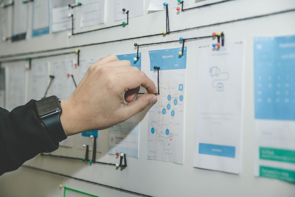 hand pinning note to whiteboard